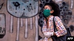 Una mujer usa nasobuco y guantes a su paso el lunes por una calle de La Habana (Yamil Lage/AFP).