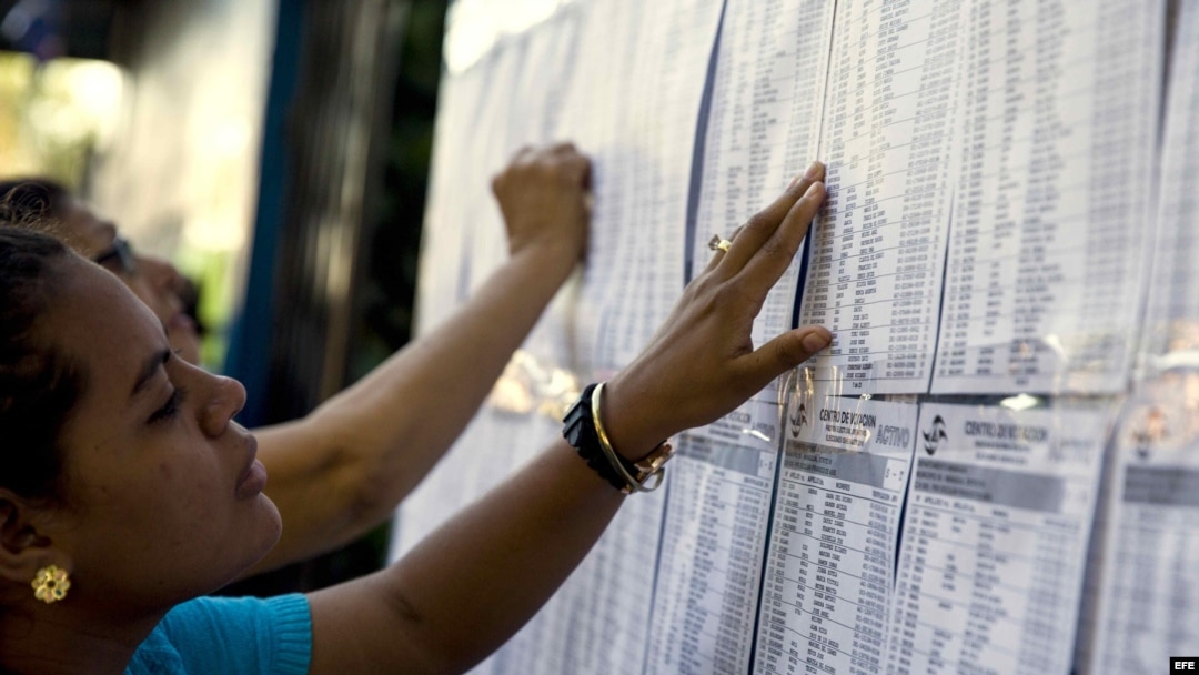 Ciudadanos nicaragüenses se buscan en la lista del padrón electoral antes de la apertura de las juntas receptoras de votos en Managua.