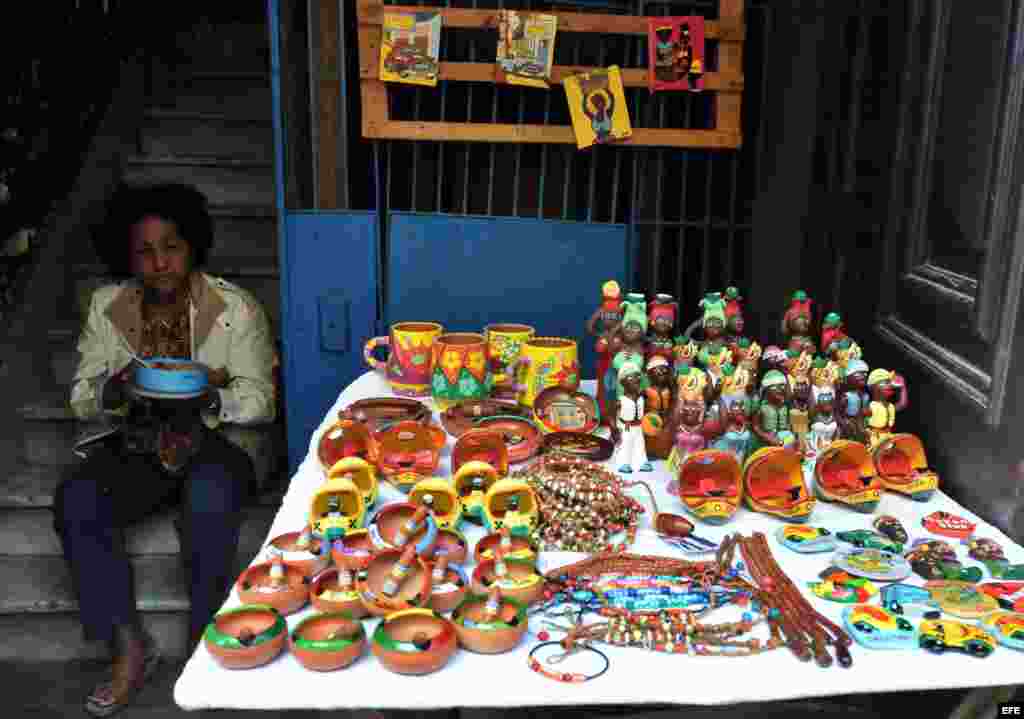 Una mujer vende artesanías y almuerza junto a su puesto.