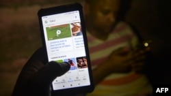 Jóvenes cubanos conectándose a internet desde su teléfono celular (Photo by YAMIL LAGE / AFP)