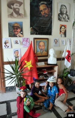 Cuatro niños disfrazados posan junto a retratos de Fidel Castro, Raúl , el 'Che' Guevara, en un círculo infantil.tre otros.