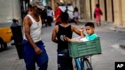 Un padre lleva a su hijo en la cesta de la bicicleta por una calle de La Habana. (AP/Ramon Espinosa/Archivo)