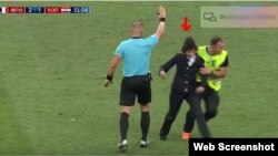 Un agente de seguridad detiene a una de las personas que invadió la cancha en la final del mundial de fútbol. 