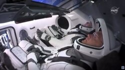 Los astronautas Bob Behnken (fondo)y Doug Hurley, dentro de la cápsula SpaceX Crew Dragon. (Foto/NASA TV)