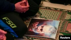 Un hombre reza sobre un retrato del general iraní Qasem Solemaini, abatido por fuerzas de EEUU. (REUTERS/Ali Hashisho)