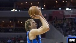 Dirk Nowitzki (i) de los Dallas Mavericks se dispone a lanzar la bola…