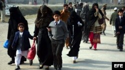 Varios alumnos acompañan a sus madres tras ser rescatados por las Fuerzas de Seguridad durante el ataque talibán contra un colegio gestionado por el Ejército en Peshawar (Pakistán).