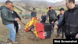 Activistas cubanos en Chile queman banderas del 26 de julio por centenario del natalicio de Fidel Castro. Captura de video. 