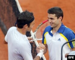 Federer (i) y Simon (d) estrechan manos tras concluir el partido.