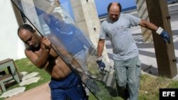 Archivo - Trabajadores desmontan vidrios en el malecón de La Habana (Cuba).