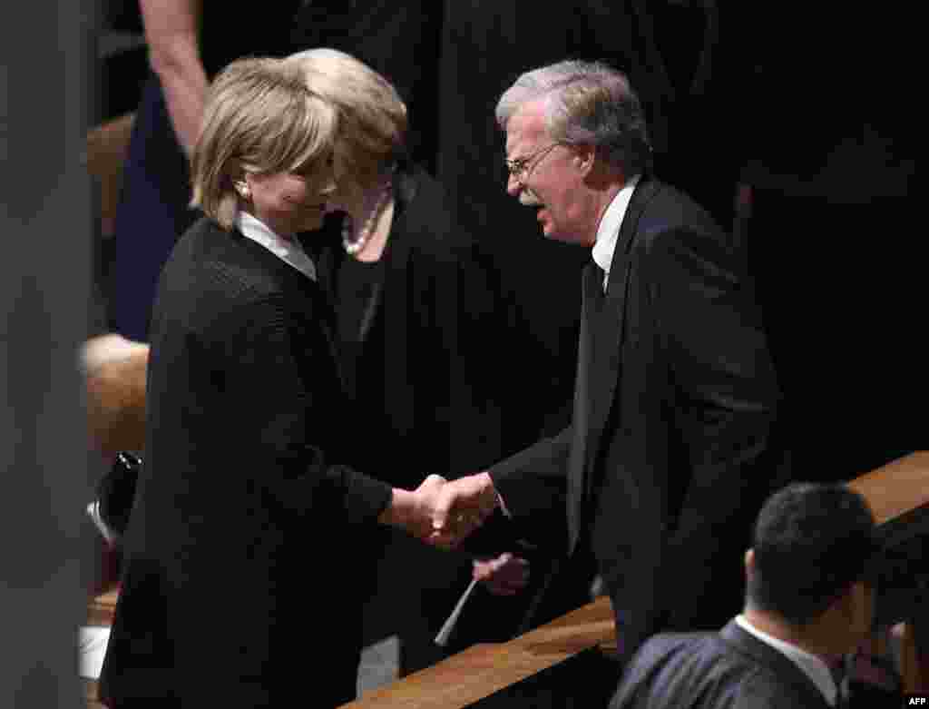 Hillary Clinton saluda al asesor de Seguridad Nacional John Bolton.