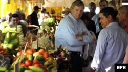 El secretario de Agricultura de Estados Unidos, Thomas Vilsack, conversa con comerciantes durante una visita a un mercado agropecuario.