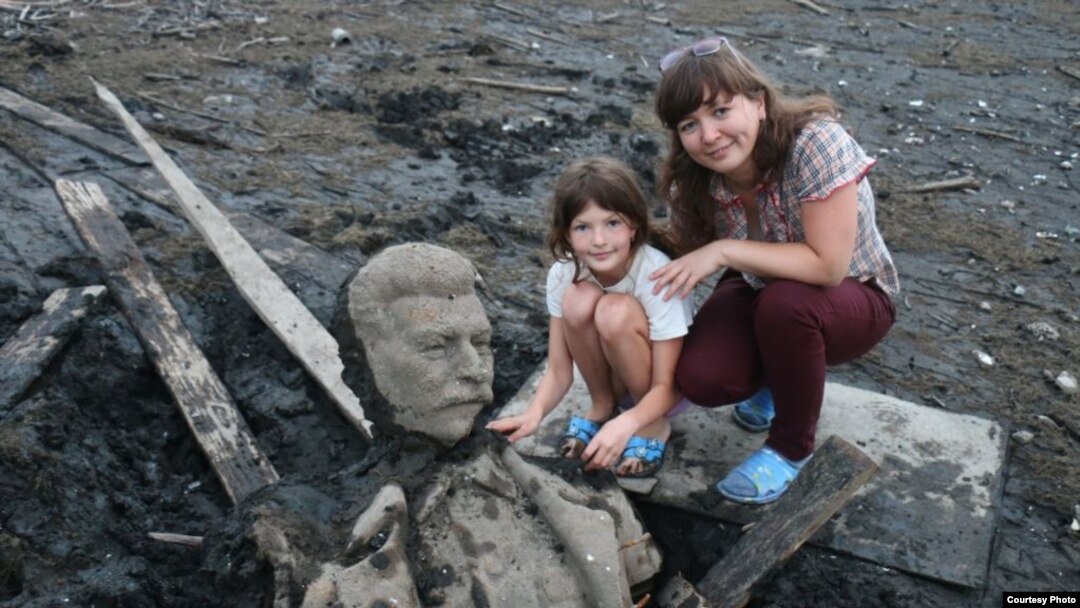 La esposa y la hija del fotógrafo Andrei Parfyonov posan con fragmentos de la estatua de Stalin.