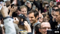 El tenista suizo Roger Federer (C) saluda a sus seguidores junto a su trofeo del Abierto de Australia a su llegada al aeropuerto de Zúrich (Suiza) hoy, 30 de enero de 2018.