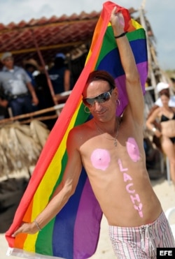 Un hombre sostiene la bandera gay en una playa de La Habana.