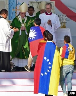 Un peregrino con la bandera de Venezuela se acerca a saludar al papa Francisco durante una misa en Ciudad Panamá.