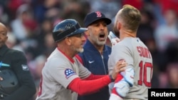 Alex Cora (centro) fue despedido como manager por los Medias Rojas.