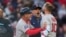 Alex Cora (centro) fue despedido como manager por los Medias Rojas.