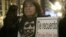An opponent of the late Chilean dictator Augusto Pinochet holds poster of Chilean singer Victor Jara, who was  murdered during Pinochet's dictatorship, at Sant Jaume square in Barcelona December 11, 2006. The poster reads, "I remind you, we all were Victo