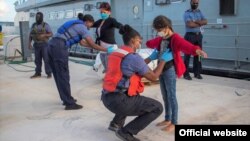 El grupo de cubanos, entre ellos una niña, es requisado por las autoridades a su llegada a la Base de Coral Harbour, el jueves 24 de junio de 2021. (Foto: RBDF/suboficial Al Rahming)