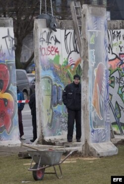 Policías hace guardia en la zona donde desmantelan parte del muro de Berlín, Alemania.