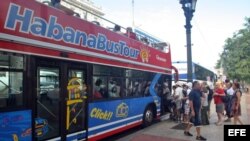 Turistas abordan un autobús turístico en La Habana (Cuba).