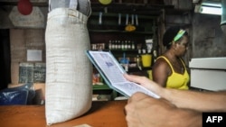 Un hombre espera comida en una tienda mientras sostiene una "libreta".