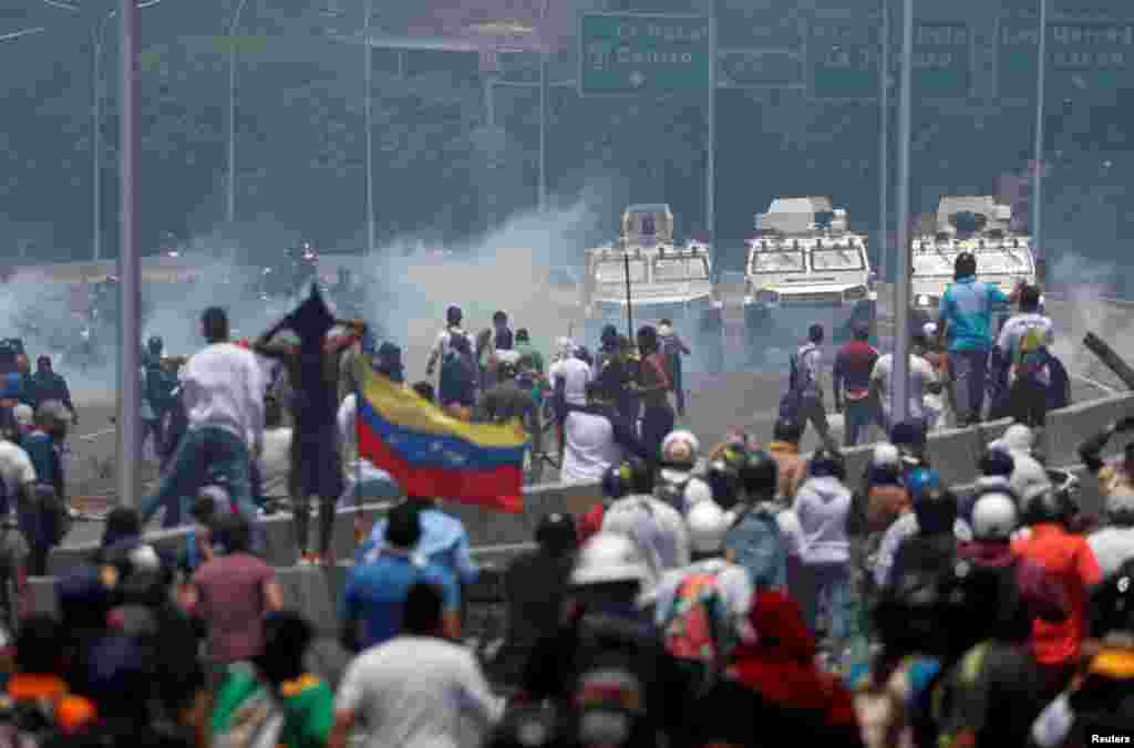 Manifestantes enfrentan los vehículos militares, cerca de la base La Carlota, en Caracas. 