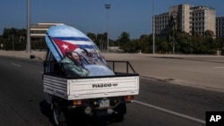 Una moto-camión transporta un póster de Fidel Castro con la bandera de Cuba por la Plaza de la Revolución, en La Habana, el 2 de marzo del 2021. 