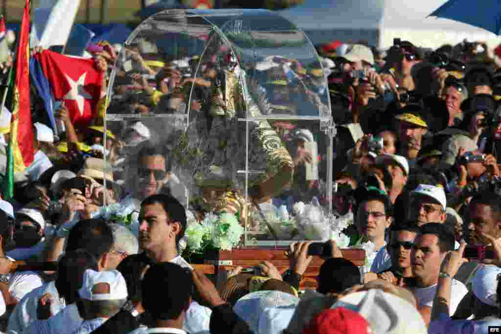 Un grupo de hombres carga una imagen de la Virgen de la Caridad entre cientos de personas que asistieron, el 28 de marzo de 2012, a la Plaza de la Revolución José Martí, en La Habana, donde el papa Benedicto XVI ofició una misa multitudinaria.