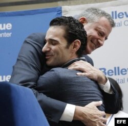 El alcalde de Nueva York Bill de Blasio (i) abraza al médico estadounidense Craig Spencer.