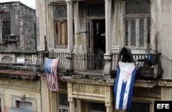 Un hombre cuelga una bandera de Cuba después de colgar la de EE.UU. hoy, lunes 21 de marzo de 2016, en La Habana (Cuba).