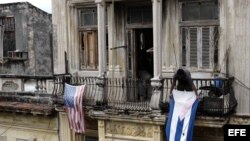 Un hombre cuelga una bandera de Cuba después de colgar la de EE.UU. hoy, lunes 21 de marzo de 2016, en La Habana (Cuba).