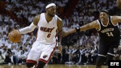 El jugador del Heat LeBron James (i) es marcado por Paul Pierce (d), de los Nets.