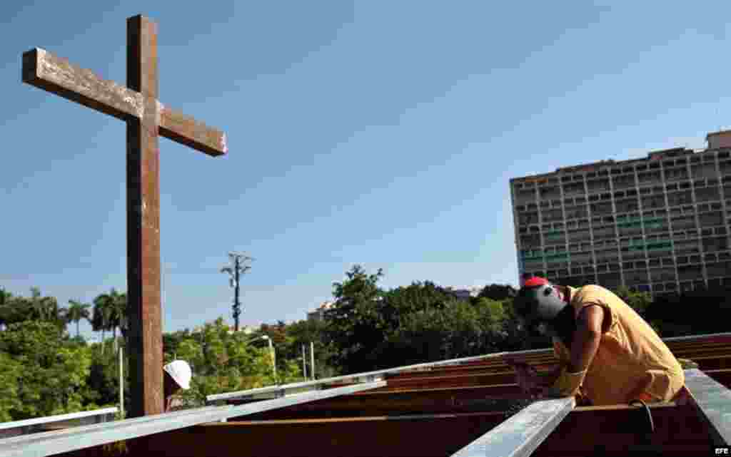 Obreros cubanos trabajan en la construcción del altar.