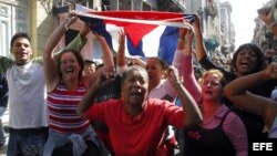 impatizantes del Gobierno cubano gritan consignas revolucionarias mientras el grupo de mujeres Las Damas de Blanco.