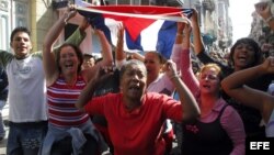Simpatizantes del gobierno cubano gritan consignas revolucionarias frente al grupo de mujeres Las Damas de Blanco.