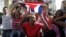 Simpatizantes del gobierno cubano gritan consignas revolucionarias frente al grupo de mujeres Las Damas de Blanco.