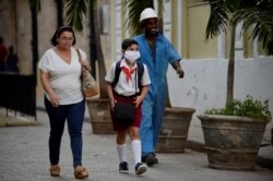 Un niño sa una máscara protectora para ir a la escuela, que no han cerrado en Cuba en medio de la epidemia de coronavirus.