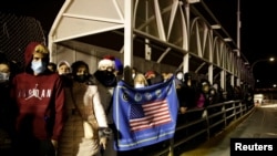 Migrantes cubanos bloquean el puente fronterizo Paso del Norte, exigiendo que se les permita cruzar y solicitar asilo en los Estados Unidos, en Ciudad Juárez, México, 29 de diciembre de 2020. (REUTERS / José Luis González).