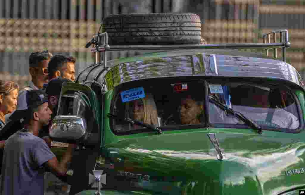 La gente intenta subirse a un taxi colectivo en La Habana, Cuba, el jueves 6 de abril de 2023. (Foto AP/Ramón Espinosa)