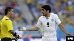 El delantero uruguayo Luis Suárez (d) discute una jugada con el árbitro mexicano Marco Rodríguez (i), durante el partido Italia-Uruguay, del Grupo D del Mundial de Fútbol de Brasil 2014.