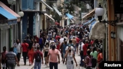 Decenas de personas caminan por una calle comercial de La Habana en medio de las medidas de control por el COVID-19. REUTERS/Alexandre Meneghini
