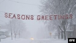 Un letrero de "Felices Fiestas" es cubierto por la nieve en una calle de Beaver Dam, estado de Wisconsin (EEUU). 