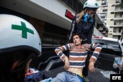 Un manifestante herido es atendido por personal de emergencia, durante los bloqueos en rechazo a las elecciones de la Asamblea Nacional Constituyente.