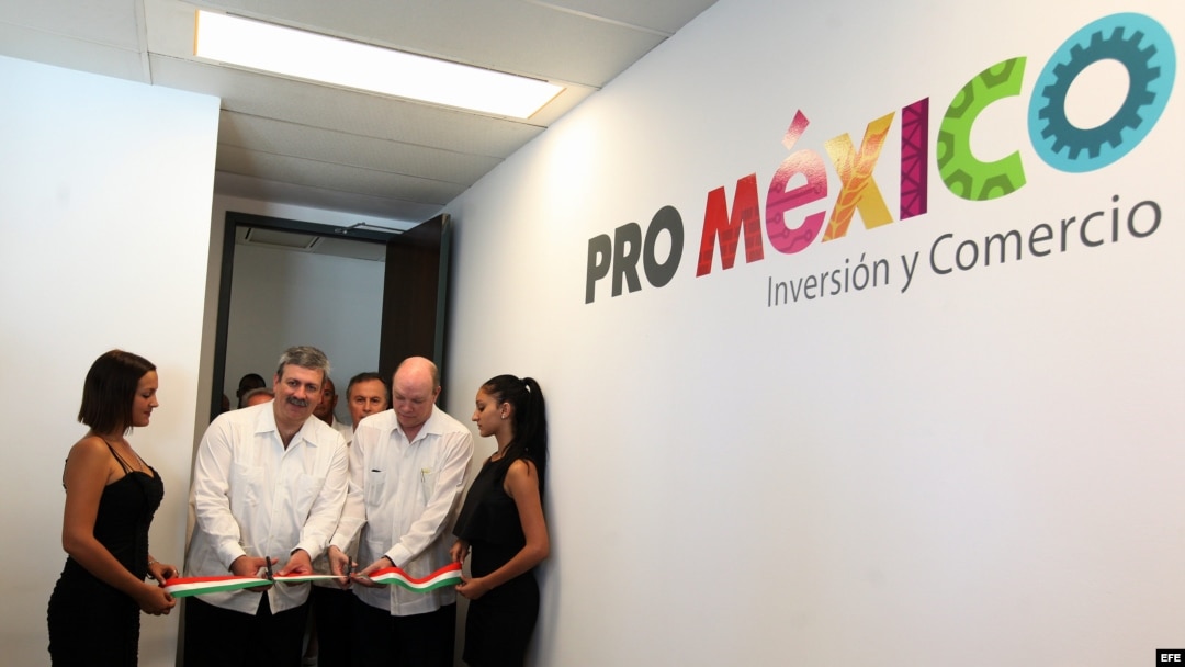 El director general de ProMéxico, Francisco N. González Díaz (i), y el ministro cubano de Comercio Exterior e Inversión Extranjera, Rodrigo Malmierca (d), cortan la cinta durante la inauguración de la oficina de ProMéxico en La Habana.