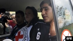 Los policías colombianos Víctor Alfonso González y Cristian Camilo Yate pasan junto a la prensa en un vehículo hoy, viernes 15 de febrero de 2013, luego de ser liberados por las FARC 