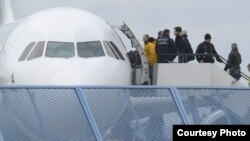 Un grupo de deportados sube a un avión en el aeropuerto de Baden, en Rheinmünster, Alemania.