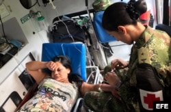 Una soldado brinda atención médica a una mujer que resultó herida durante la avalancha.