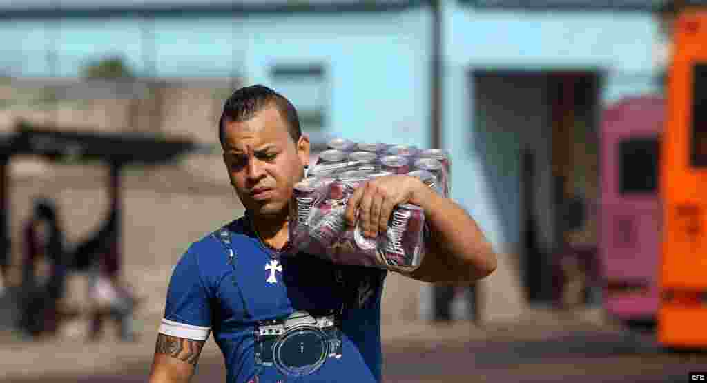 Un hombre camina con una caja de cervezas el miércoles 31 de diciembre de 2014, en La Habana (Cuba).